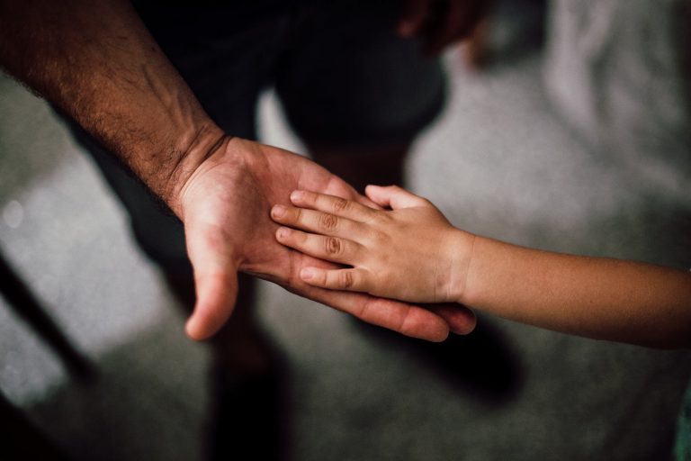 selective focus photography of child s hand